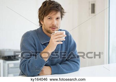Portrait of a mid adult man holding a cup of tea View Large Photo Image Stock Photograph - Portrait of a mid adult man holding a cup of tea. Fotosearch