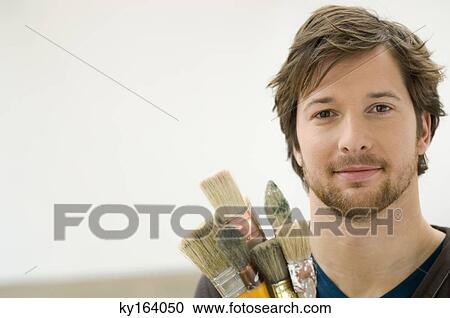 Portrait of a mid adult man holding paintbrushes View Large Photo Image Stock Image - Portrait of a mid adult man holding paintbrushes. Fotosearch