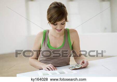 Young woman matching a tile with a color swatch on a table View Large Photo Image Stock Photo - Young woman matching a tile with a color swatch on a table. Fotosearch