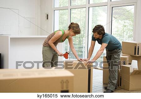 Couple packing cardboard boxes View Large Photo Image Stock Photography - Couple packing cardboard boxes. Fotosearch
