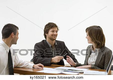 Mid adult man giving a pen to a young woman View Large Photo Image Stock Image - Mid adult man giving a pen to a young woman. Fotosearch