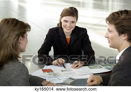 Picture - Real estate agent explaining to a couple. Fotosearch