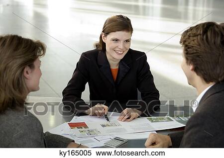 Real estate agent explaining to a couple View Large Photo Image Stock Photography - Real estate agent explaining to a couple. Fotosearch