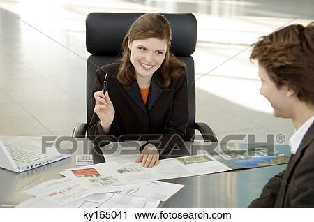 Real estate agent explaining to a young man View Large Photo Image Stock Image - Real estate agent explaining to a young man. Fotosearch