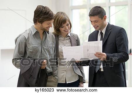 Real estate agent showing a blueprint to a couple View Large Photo Image Stock Image - Real estate agent showing a blueprint to a couple. Fotosearch