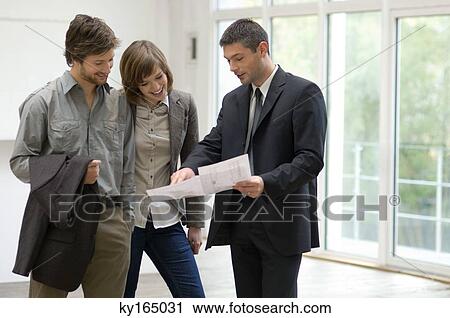 Real estate agent showing a blueprint to a couple View Large Photo Image Stock Image - Real estate agent showing a blueprint to a couple. Fotosearch