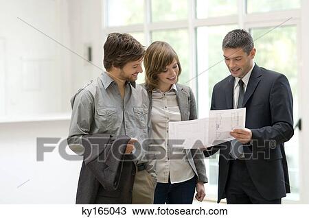 Real estate agent showing a blueprint to a couple View Large Photo Image Stock Image - Real estate agent showing a blueprint to a couple. Fotosearch