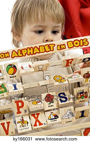 Stock Image - Close-up of a baby boy playing with alphabet blocks. Fotosearch