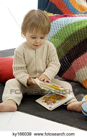Close-up of a baby boy sitting and holding picture books View Large Photo Image Stock Photo - Close-up of a baby boy sitting and holding picture books. Fotosearch