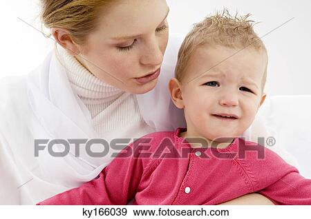 Close-up of a young woman carrying her crying son View Large Photo Image Stock Photo - Close-up of a young woman carrying her crying son. Fotosearch