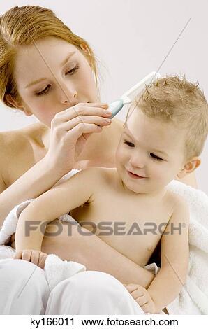 Close-up of a young woman combing hair of her son View Large Photo Image Stock Image - Close-up of a young woman combing hair of her son. Fotosearch
