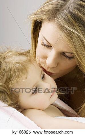 Close-up of a young woman kissing her son View Large Photo Image Stock Photography - Close-up of a young woman kissing her son. Fotosearch