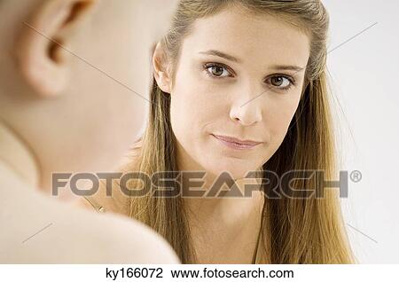 Close-up of a young woman looking at her son View Large Photo Image Stock Image - Close-up of a young woman looking at her son. Fotosearch