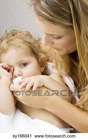 Close-up of a young woman wiping her son's mouth View Large Photo Image Stock Image - Close-up of a young woman wiping her son's mouth. Fotosearch