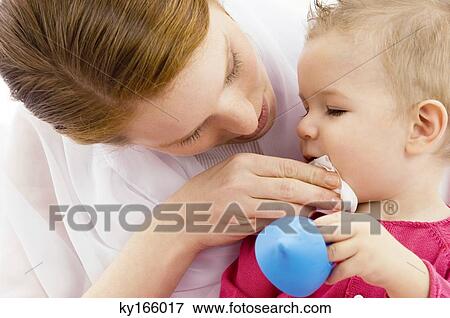 Stock Photo - Close-up of a young woman wiping her son's mouth. Fotosearch