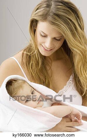 Close-up of a young woman wrapping her son in a towel and smiling View Large Photo Image Stock Image - Close-up of a young woman wrapping her son in a towel and smiling. Fotosearch