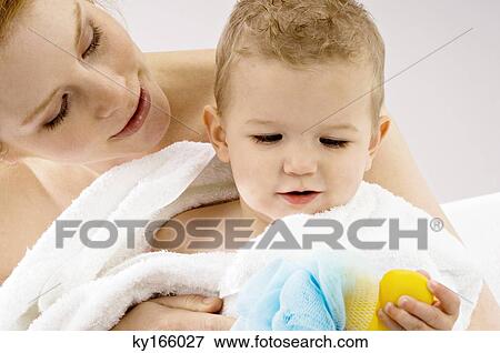 Close-up of a young woman wrapping her son in a towel View Large Photo Image Stock Photo - Close-up of a young woman wrapping her son in a towel. Fotosearch