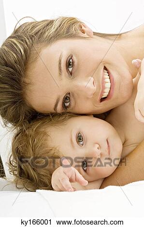 Stock Image - Portrait of a young woman smiling with her son. Fotosearch