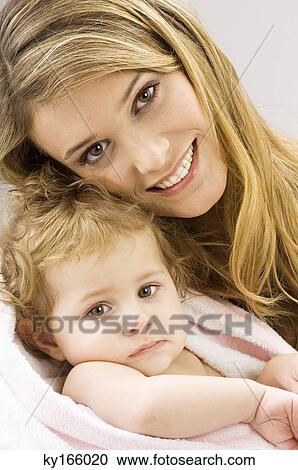 Portrait of a young woman wrapping her son in a towel and smiling View Large Photo Image Stock Image - Portrait of a young woman wrapping her son in a towel and smiling. Fotosearch