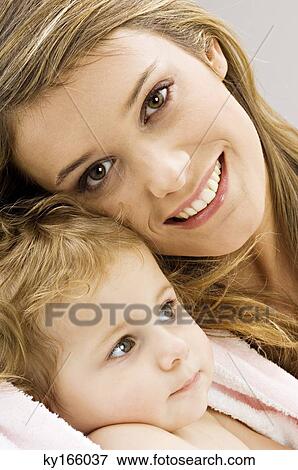 Portrait of a young woman wrapping her son in a towel and smiling View Large Photo Image Stock Photo - Portrait of a young woman wrapping her son in a towel and smiling. Fotosearch