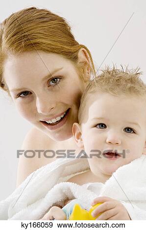 Portrait of a young woman wrapping her son in a towel and smiling View Large Photo Image Stock Photo - Portrait of a young woman wrapping her son in a towel and smiling. Fotosearch