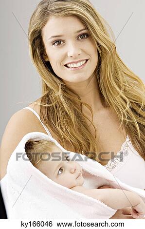 Portrait of a young woman wrapping her son in a towel and smiling View Large Photo Image Stock Photograph - Portrait of a young woman wrapping her son in a towel and smiling. Fotosearch