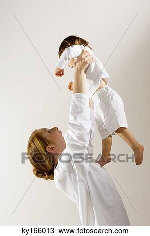 Side profile of a young woman lifting up her son View Large Photo Image Stock Image - Side profile of a young woman lifting up her son. Fotosearch