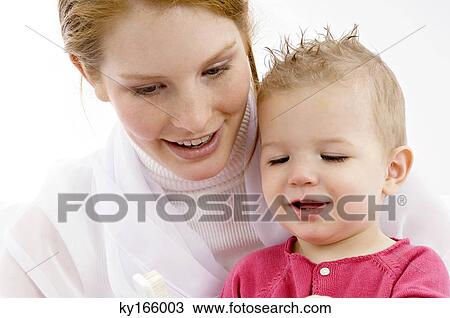Stock Image - Young woman and her son looking at toothbrush. Fotosearch