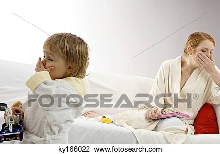 Young woman and her son yawning View Large Photo Image Stock Image - Young woman and her son yawning. Fotosearch