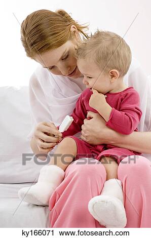 Young woman holding a toothbrush with her son sitting on her lap View Large Photo Image Stock Image - Young woman holding a toothbrush with her son sitting on her lap. Fotosearch