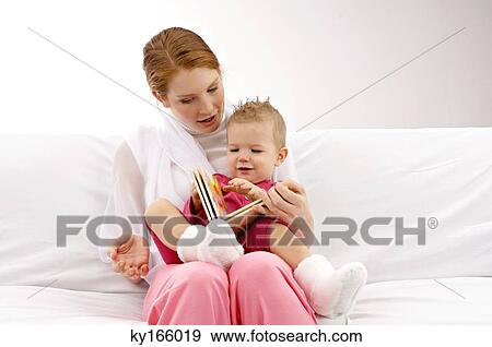 Young woman showing a picture book to her son View Large Photo Image Stock Photo - Young woman showing a picture book to her son. Fotosearch