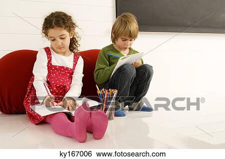Stock Photograph - Boy and a girl drawing on notepads. Fotosearch