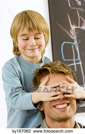 Stock Image - Boy covering eyes of his father. Fotosearch