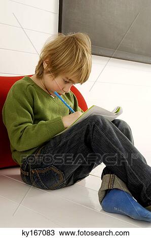 Stock Image - Boy holding a note book and a pencil. Fotosearch