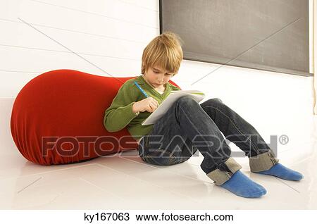 Stock Image - Boy holding a note pad and a pencil. Fotosearch