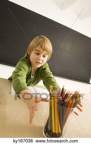 Stock Photograph - Boy reaching out for a pencil holder. Fotosearch