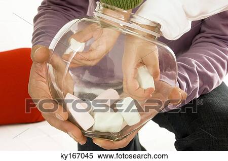 Stock Photography - Children picking up marshmallows from a glass container held by his father. Fotosearch