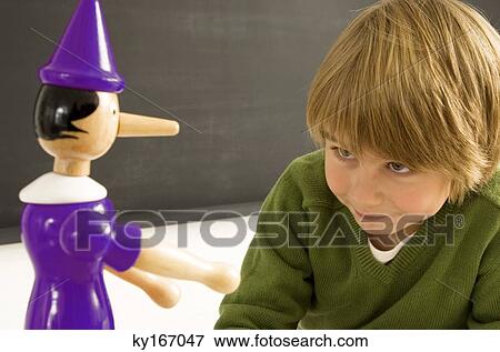 Close-up of a boy looking at a toy View Large Photo Image Stock Photo - Close-up of a boy looking at a toy. Fotosearch