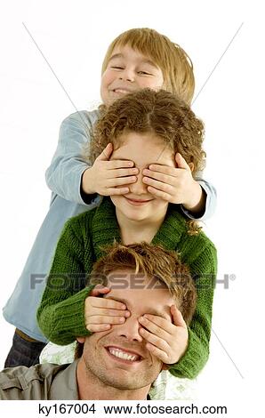 Girl covering eyes of her father and her eyes covered by her brother View Large Photo Image Picture - Girl covering eyes of her father and her eyes covered by her brother. Fotosearch