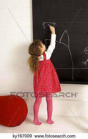 Girl drawing on a blackboard View Large Photo Image Stock Photo - Girl drawing on a blackboard. Fotosearch