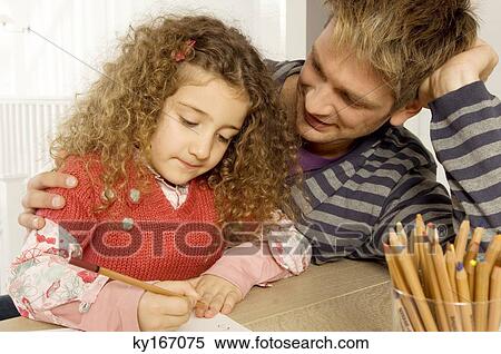 Girl drawing with her father sitting beside her View Large Photo Image Stock Photography - Girl drawing with her father sitting beside her. Fotosearch