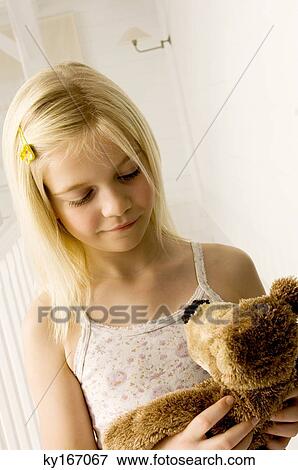 Stock Photo - Girl holding a teddy bear. Fotosearch