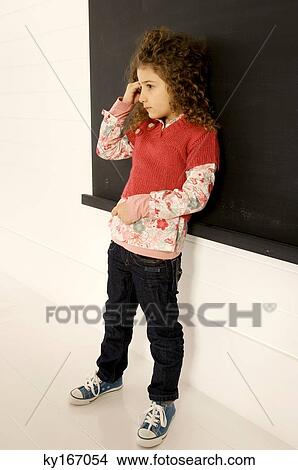 Girl standing in front of a blackboard View Large Photo Image Picture - Girl standing in front of a blackboard. Fotosearch