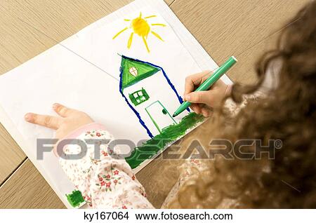 Picture - High angle view of a girl coloring on a sheet of paper. Fotosearch