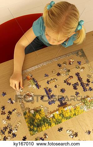 High angle view of a girl playing a jigsaw puzzle View Large Photo Image Stock Image - High angle view of a girl playing a jigsaw puzzle. Fotosearch