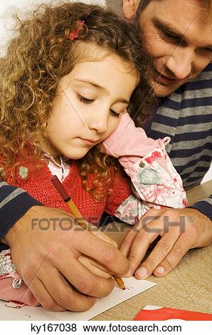 Mid adult man helping his daughter in drawing View Large Photo Image Stock Photo - Mid adult man helping his daughter in drawing. Fotosearch