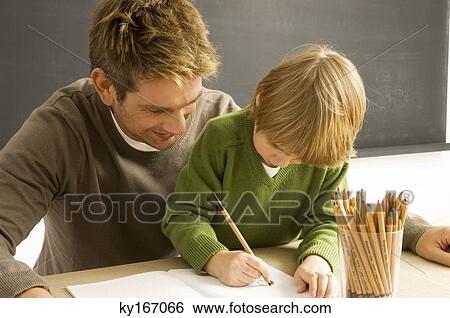 Mid adult man helping his son in drawing View Large Photo Image Stock Photograph - Mid adult man helping his son in drawing. Fotosearch
