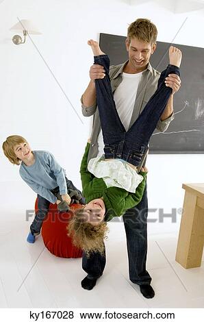 Mid adult man playing with his children View Large Photo Image Stock Photo - Mid adult man playing with his children. Fotosearch