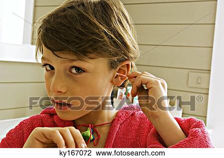 Portrait of a boy cleaning his ear with a cotton swab View Large Photo Image Stock Image - Portrait of a boy cleaning his ear with a cotton swab. Fotosearch
