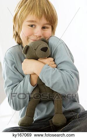 Portrait of a boy holding a teddy bear View Large Photo Image Stock Photo - Portrait of a boy holding a teddy bear. Fotosearch